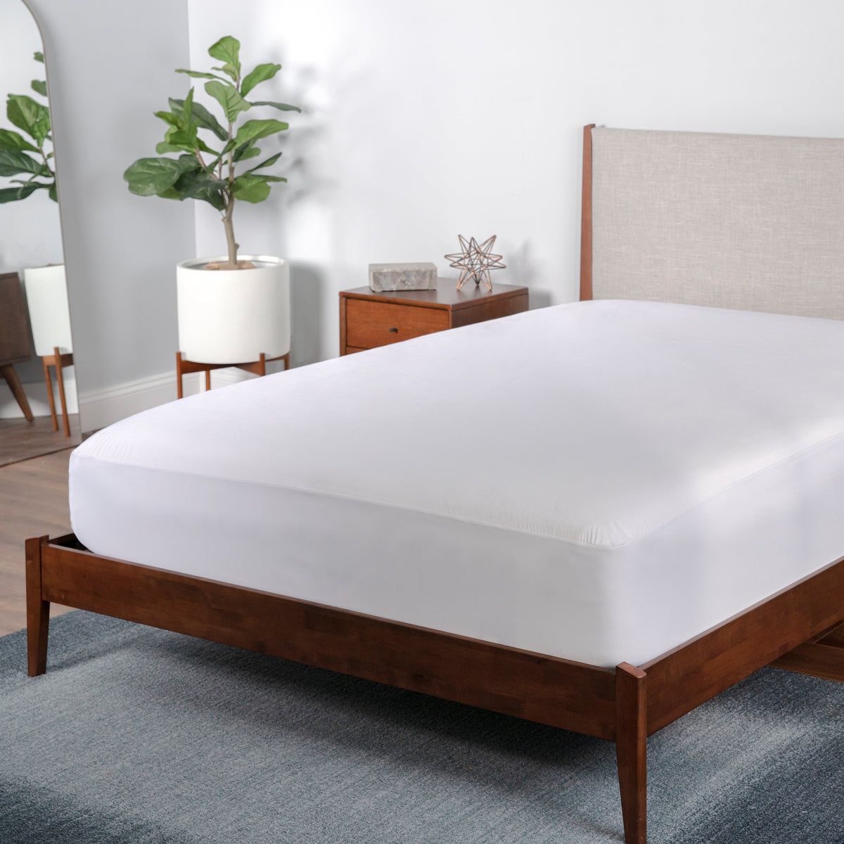 A mattress protector sitting on a bed frame.