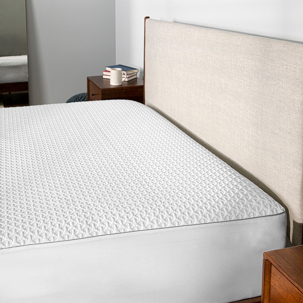 A Ver-Tex mattress protector on a bed frame. 