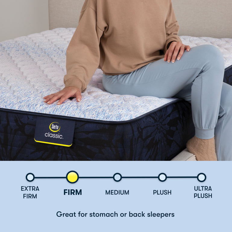 Person sitting on edge of Classic Dorian Firm Serta mattress | Ideal for back and stomach sleepers with firm support
