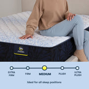 Person sitting on edge of Classic Alden Medium Serta mattress | Ideal for all sleep positions with medium firmness