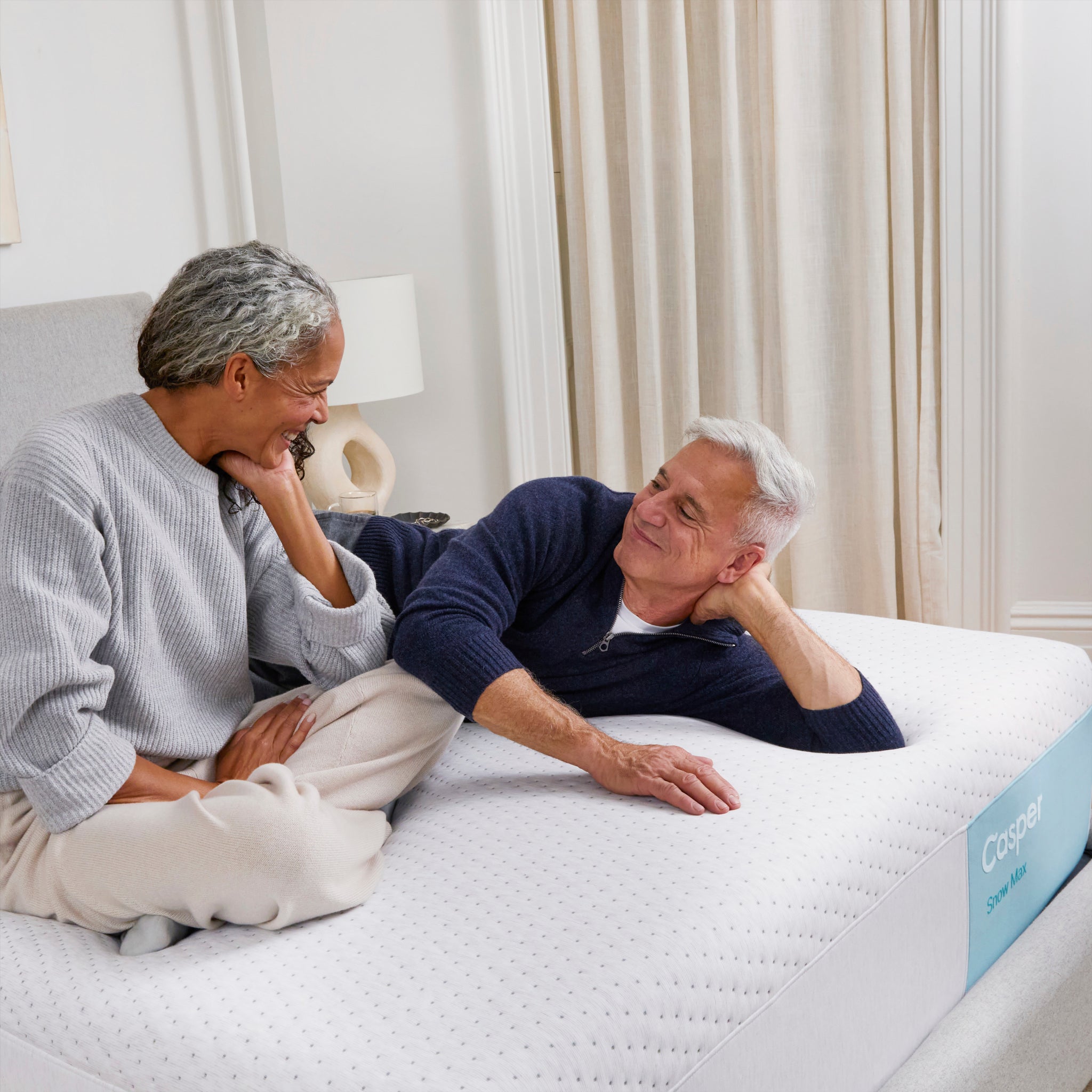 Couple relaxing on Snow Max Mattress by Casper | Cooling comfort and ergonomic support